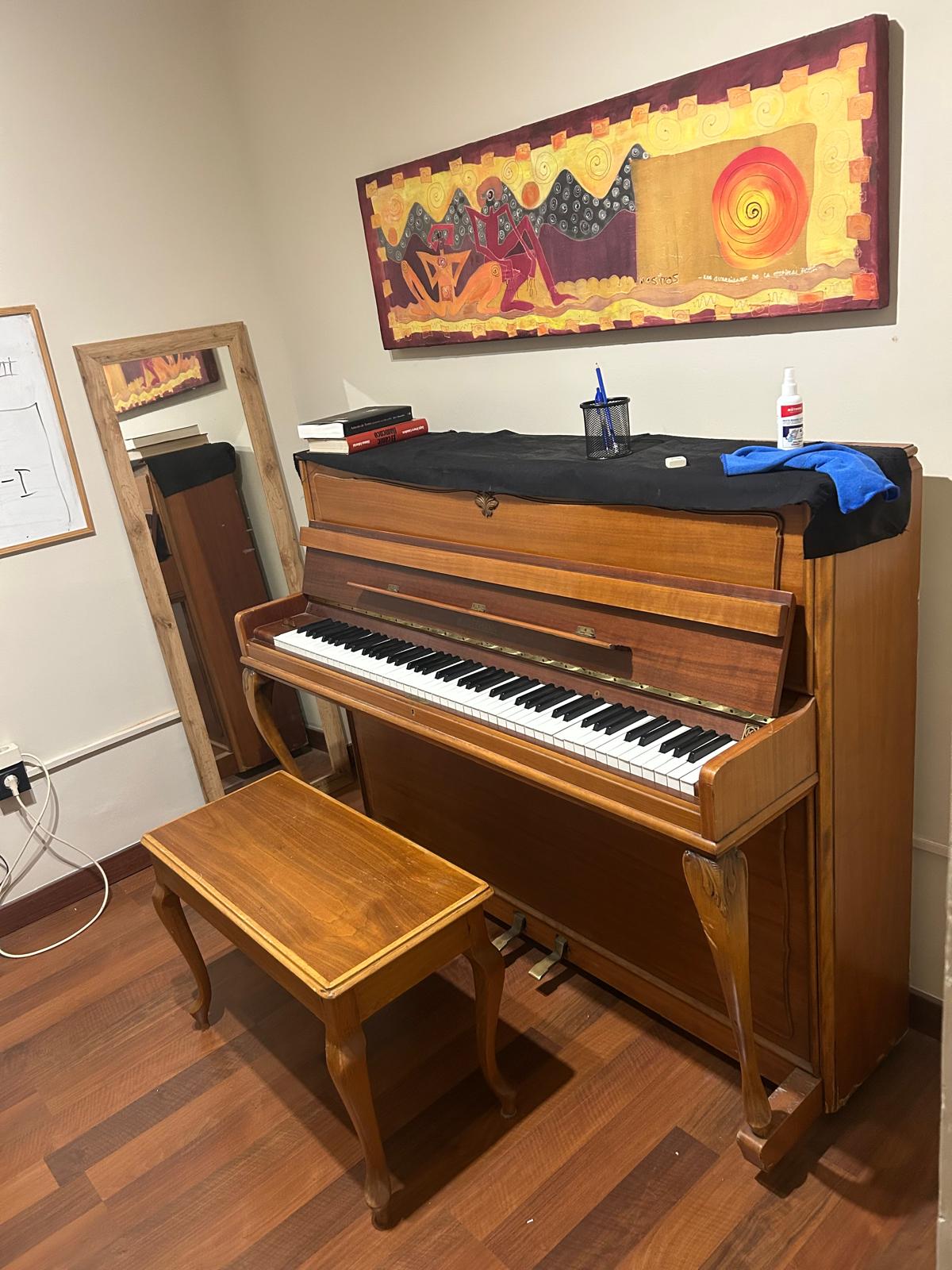 Sala de ensayo de la academia con piano de cola y luz natural